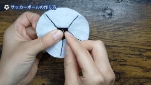 黒い糸を２本取りでバックステッチしていき、中央に5角形を縦まつり縫いで縫い付ける。